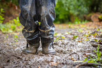 Child in welly boots, jump, jumping in mud.