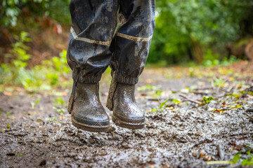 Child in welly boots, jump, jumping in mud.