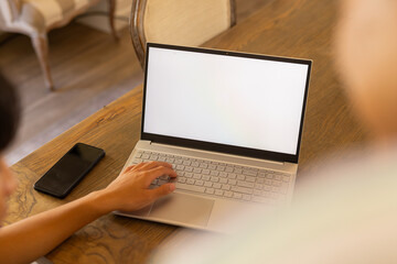 Using laptop and smartphone, person working from home at wooden table, copy space