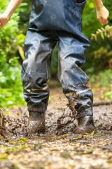 Child in welly boots, jump, jumping in mud.