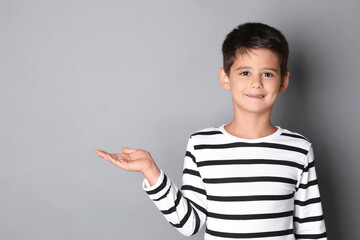 Portrait of cute little boy on grey background