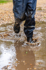 Child in welly boots, jump, jumping in mud.