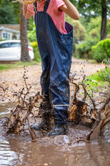 Child in welly boots, jump, jumping in mud.