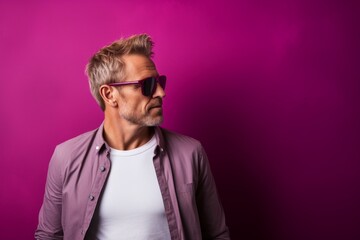 Fototapeta premium Portrait of a satisfied man in his 40s wearing a trendy sunglasses over plain cyclorama studio wall
