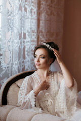 Fototapeta premium A woman is sitting on a chair wearing a white gown and a headband. She is looking at the camera with a smile on her face. Concept of elegance and sophistication