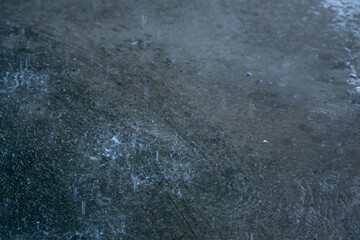 Raindrops on the surface of the puddle. Shallow depth of field.