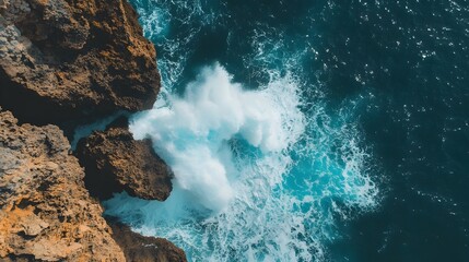 Obraz premium Powerful ocean wave crashing forcefully against rugged rocky cliffs symbolizing the raw power and dynamic energy of the natural world along the coastline