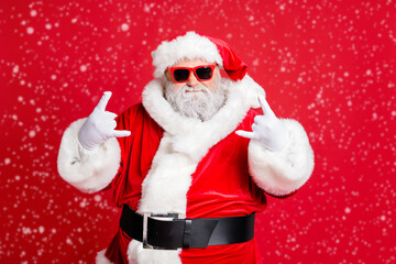 Portrait of his he funky confident content fat overweight plump gray-haired bearded man St Saint Nicholas having fun showing horn sign symbol isolated over bright vivid shine red background