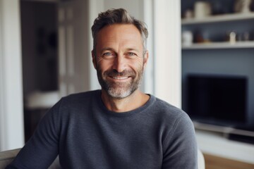 Obraz premium Portrait of a satisfied man in his 40s wearing a cozy sweater over crisp minimalistic living room