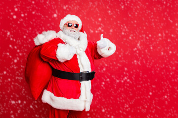 Portrait of his he cheerful cheery glad confident funky fat overweight plump gray-haired bearded man piggy backing bag showing thumbup isolated over bright vivid shine red background
