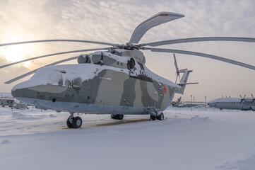 A large military helicopter on a winter field. A rotary-wing aircraft for vertical takeoff and...