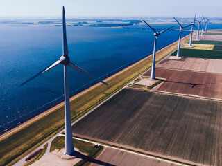 Birds eye view of windmills station with green energy resources generation from wind power on scenic vast area of agriculture fields.Alternative electricity production with rotating turbines in meadow