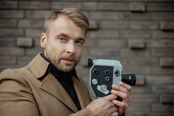 Fashion portrait of young pretty hipster  beard man, jacket, with retro camara,big full bright lips,soft vintage colors,stylish outfit, producer movie, moods, fashion model, lens, urban wall, NYC