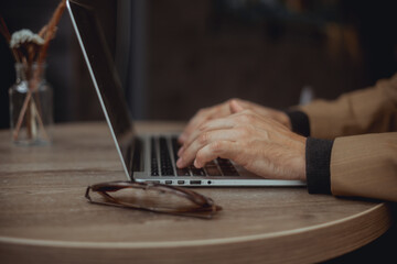 Young beard man using laptop on office, freelance work, outdoor close up hipster portrait, brutal, guy listening music on earphones, make photo and video, production, Bali, coffee cup, smartphone