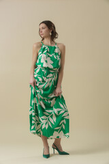 Serie of studio photos of young female model in large floral green linen long camisole dress....