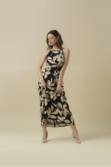 Serie of studio photos of young female model in large floral black and beige linen long camisole dress. Casual and stylish summertime outfit, spring-summer fashion trend.