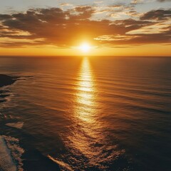 Fototapeta premium Illustrate a picturesque golden sunset spreading its beauty over a vast ocean from a birds eye view
