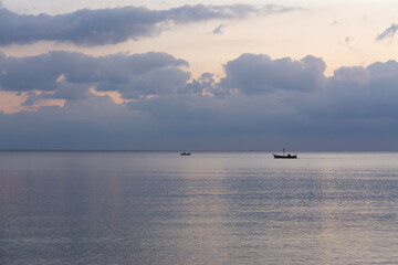 Boats on calm sea under a gray sky