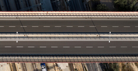 Aerial zenithal view of a bridge with an empty highway. There are two lanes for each direction.