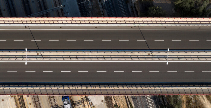 Aerial zenithal view of a bridge with an empty highway. There are two lanes for each direction.