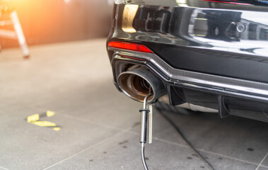 Professional exhaust fume measurement of a modern sports car in a car shop