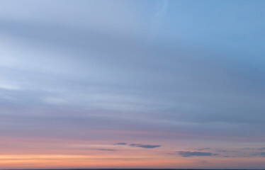 Beautiful pastel-colored sky at sunset with soft clouds. Peaceful evening landscape with gradient colors of blue and pink in the horizon. Ideal for backgrounds or serene scenes.