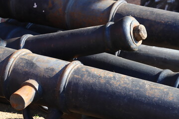 cast iron gun barrels stacked in a pile