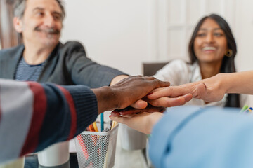 Diverse team unity, multiethnic colleagues joining hands, workplace inclusion and collaboration