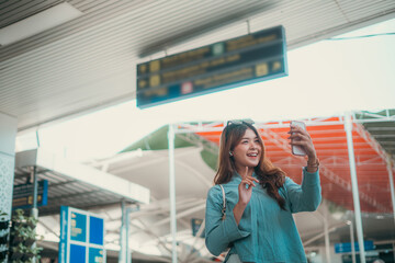 A cheerful traveler is taking a selfie at the airport gate while waiting for their flight