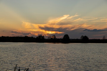 Naklejka premium beautiful bright sunset on the lake in the summer