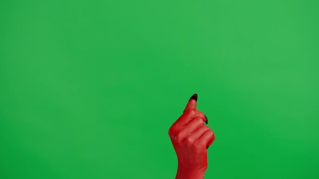 Creepy halloween devil monster hand in red paint with black nails flicking fingers, isolated on chroma key green screen background, workspace mockup.