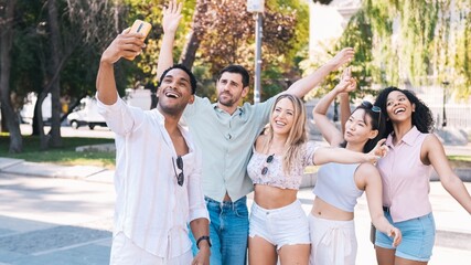 Happy multiethnic friends taking self-portrait in city during sunny day