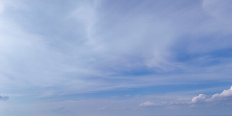 Bright blue sky with soft white clouds, creating a serene, calm atmosphere. Ideal for backgrounds or nature-related uses, symbolizing peace, simplicity, and tranquility.