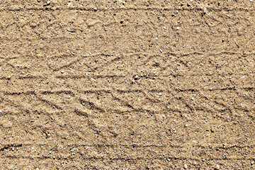 Sand tyre mark background. Tire track shape. Trail lines on dry brown sand pattern. Road construction site backdrop. Heavy machinery imprint. Dried mud vehicle wheel shape.