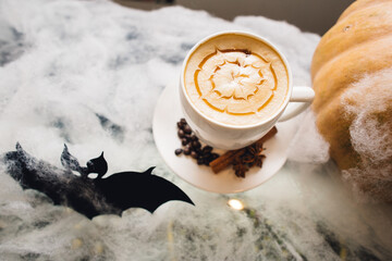 Halloween-themed latte with pumpkin and spooky decor