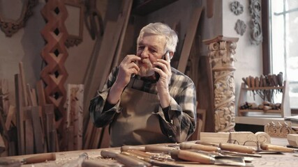 Camera view of Caucasian man talking on cellphone. Older carpenter with grey beard discussing next project with potential customer. Concept of remote communication. Using mobile phone. - Powered by Adobe