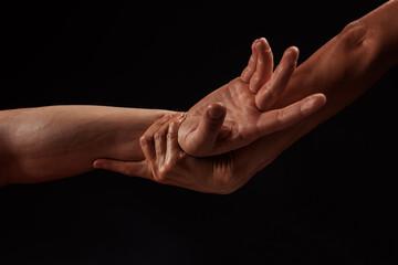 girl masseur doing hand massage to man on dark background close-up, beautiful relaxation massage