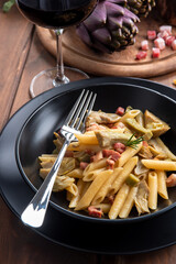 Pasta con carciofi e pancetta, cibo italiano 