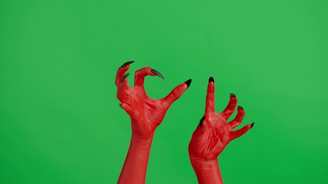 Creepy halloween devil monster hand in red paint with black nails crawling with both hands, isolated on chroma key green screen background, workspace mockup.
