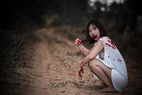 Portrait of asian woman make up ghost face,Horror scene,Scary background,Halloween poster,Thailand people,Lady has a axe in hand,Lovely zombie concept