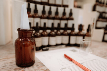 Clean mockup of glass brown bottle with white blotter paper for testing smell of fragrance oil or...