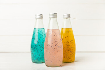 Diet detox cocktail with basil and chia seeds in a glass jar and a glass on a textured background....
