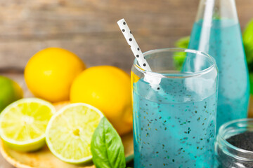 Diet detox cocktail with basil and chia seeds in a glass jar and a glass on a textured background....