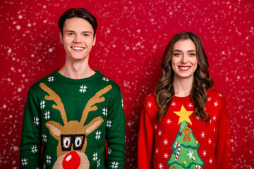 Photo of cheerful positive bright people wear ugly sweater rejoice magic time season sale decor gift shop isolated on red color background