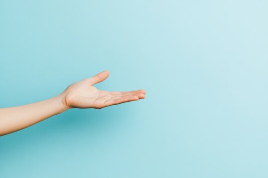 A person extending their hand in a welcoming gesture against a soft blue background to convey openness and friendliness