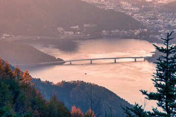 Lake Kawaguchiko with autumn foliage at sunrise in Fujikawaguchiko, Japan.