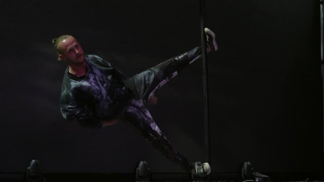 A circus performer is doing tricks on a pole