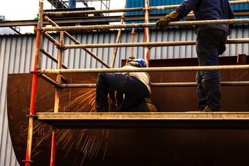 Two welders at work building a vessel in a shipyard