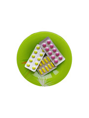 Tablets blisters medicines on a plate, knife and fork, cutlery, lunch, meal, table setting on a white background