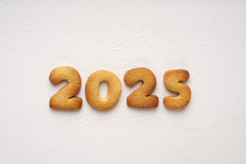 Cookies with peanuts in the form of numbers 2025 in the center on the white background